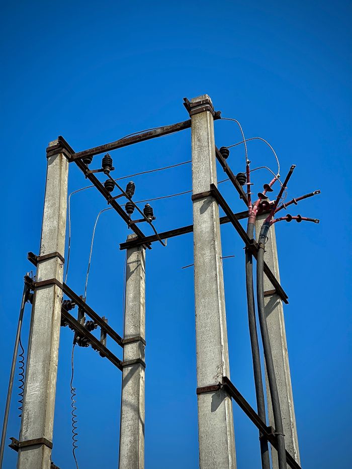 product-04 High view of concrete utility poles and wires under a clear blue sky in Mohali, India.